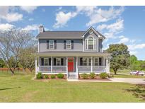 Charming two-story home features a spacious front porch, well-manicured lawn, and classic architectural details at 1020 Retriever Ln, Raleigh, NC 27603