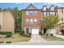 Charming two-story brick townhome features a garage and a blue front door at 117 Gallent Hedge Trl, Apex, NC 27539
