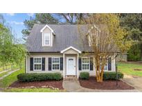 Charming home featuring neutral siding, black shutters, dormer windows, and well-maintained landscaping at 120 Stillmeadow Dr, Louisburg, NC 27549