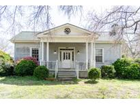 Charming single-story home with a columned front porch, dormer, and mature landscaping at 1556 Pleasants Rd, Wendell, NC 27591