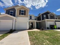 Modern townhome featuring a two-car garage and well-maintained lawn at 158 Parker Ln, Mebane, NC 27302