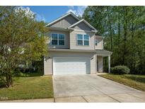 Two-story home with neutral siding, a two-car garage, and a well-maintained lawn at 1817 Heisser Ln, Fuquay Varina, NC 27526