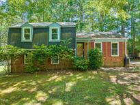 Charming two-story home with a brick facade and lush green landscaping at 2417 Lawrence Dr, Raleigh, NC 27603