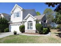 Beautiful two-story home featuring stone accents, a manicured lawn, and an attached two car garage at 409 Courthouse Dr, Morrisville, NC 27560