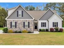 Charming two-story home with stone and board and batten siding and a well-manicured lawn at 4304 S Greg Allen Way, Oxford, NC 27565