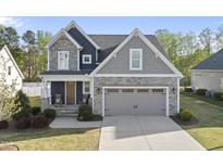Charming two-story home with stone accents, a two-car garage, and a well-manicured lawn at 45 Walking Trl, Youngsville, NC 27596