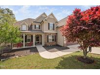 Charming two-story home with inviting front porch and beautifully landscaped front yard at 556 Rolling Meadows Dr, Clayton, NC 27527