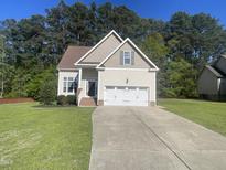 Charming home featuring a two-car garage, well-manicured lawn, and inviting curb appeal at 66 Saddle Ln, Lillington, NC 27546