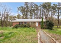 Charming single-story brick home with a well-kept lawn, mature trees, and inviting front entrance at 6702 Huntsboro Rd, Oxford, NC 27565