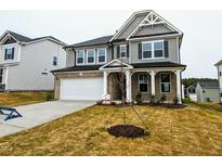 Charming two-story home with a brick and gray siding exterior and a manicured front yard at 725 Bracklyn Ave, Zebulon, NC 27597