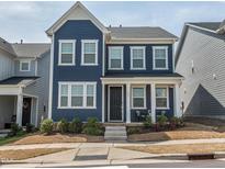 Charming blue two-story home featuring a covered front porch and well-manicured landscaping at 781 Cormiche Ln, Wake Forest, NC 27587