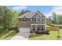 Charming two-story home with a brick and gray siding exterior, covered porch, and well-manicured lawn at 8016 Parker Mill Trl, Fuquay Varina, NC 27526