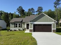 Charming home featuring green siding, a two-car garage, and a well-manicured lawn at 86 Heatherglenn Cir, Princeton, NC 27569