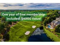 Beautiful aerial view of the golf course with a pond, mature trees, and free membership included at 9531 Vira Dr, Raleigh, NC 27617