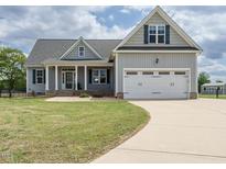 Charming two-story home with a well-manicured lawn, attached two car garage and covered front porch at 96 Ada Cir, Selma, NC 27576