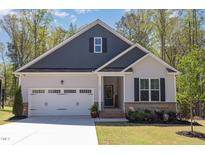 Charming single Gathering home with a two car garage and a well manicured lawn at 103 Sunlight Cv, Louisburg, NC 27549