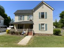 Charming two-story home featuring a well-maintained lawn, inviting front porch and traditional architectural details at 104 N 16Th St, Erwin, NC 28339