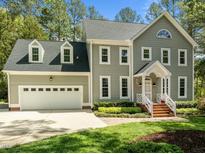 Charming two-story home with a two-car garage, manicured lawn and mature trees offering great curb appeal at 105 Toynbee Pl, Chapel Hill, NC 27514