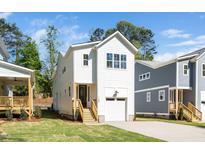 Charming white two-story home with a one-car garage and well-manicured lawn at 1207 Chaney Rd, Raleigh, NC 27606