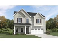 Charming two-story home featuring a front porch, two-car garage, and board and batten siding at 1572 Bright Coral Trl, Wendell, NC 27591