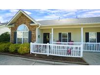 Charming townhouse featuring stone accents, a cozy front porch, and a well-maintained landscape at 201 Blithe Pl, Morrisville, NC 27560