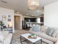 Inviting living room with modern furnishings flowing into kitchen with stainless steel appliances at 3521 Strawberry Patch Row, Raleigh, NC 27604