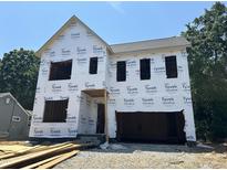 Exterior of new construction home with installed Tyvek HomeWrap, showing framed window and door openings at 406 Columbia Dr, Raleigh, NC 27604