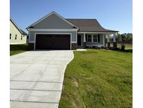Charming home featuring a two-car garage, stone accents, manicured lawn, and inviting front porch at 49 Heatherglenn Cir, Princeton, NC 27569