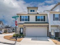 Charming two-story townhome featuring a two-car garage and a well-maintained brick facade at 518 Oak Forest View Ln, Wake Forest, NC 27587
