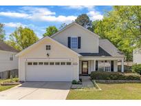 Charming two-story home with a two-car garage and a well-maintained front yard under a bright blue sky at 613 Holly Thorn, Holly Springs, NC 27540