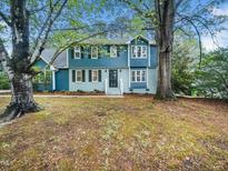 Charming two-story home with blue siding, black shutters, and mature trees at 6216 Valley Estates Dr, Raleigh, NC 27612