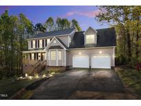 Charming two-story home with a two car garage, landscaped yard, and front porch at 7221 Messenger Dr, Willow Springs, NC 27592