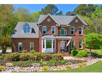 Charming brick home with manicured landscaping and a welcoming entrance with an American flag displayed at 8059 Hogan Dr, Wake Forest, NC 27587
