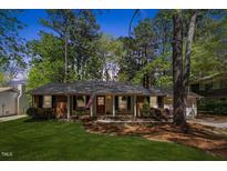 Charming single-story brick home with a manicured lawn and mature trees at 812 Northclift Dr, Raleigh, NC 27609
