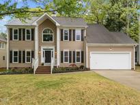 Charming two-story home featuring manicured lawn, black shutters and an attached two car garage at 8921 Walking Stick Trl, Raleigh, NC 27615