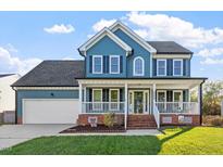 Charming two-story home with a welcoming front porch and blue siding, plus a well-manicured lawn at 9204 Cub Trl, Raleigh, NC 27615