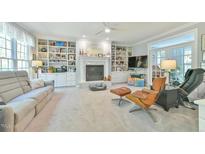 Bright living room boasts a cozy fireplace, built-in shelves, and access to the outdoor living space at 104 Buckeye Ln, Chapel Hill, NC 27516