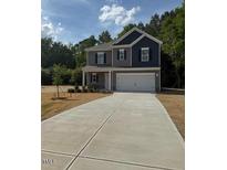 Charming two-story home featuring a gray and navy blue color scheme with a spacious two car garage at 136 Baneberry Pl, Broadway, NC 27505