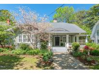 Charming home with a stone pathway, a welcoming front porch, and mature landscaping with a blooming tree at 2416 W Club Blvd, Durham, NC 27705