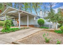 Charming home with a covered driveway and landscaped front yard and gray wood siding at 2916 Rue Sans Famille, Raleigh, NC 27607