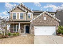 Charming two-story home with a brick and siding exterior, featuring a two-car garage and well-maintained landscaping at 3360 Bordwell Ridge Dr, New Hill, NC 27562