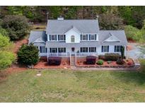 Charming two-story home with a covered front porch, black shutters, and lush landscaping at 3787 Pleasant Hill Church, Siler City, NC 27344
