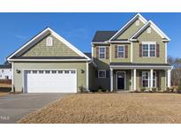 Charming two-story home with green siding, attached garage, and a well-maintained front yard at 40 Rosewood Ln, Youngsville, NC 27596