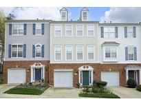 Row of townhomes showing brick facades, garage doors, and colorful front doors in a residential neighborhood at 5403 Bayside Ct, Raleigh, NC 27613
