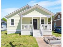 Charming home featuring a welcoming front porch and manicured lawn at 545 E Lenoir St, Raleigh, NC 27601