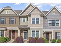 Charming townhome exterior with stone accents and a well-manicured front yard at 7822 Allscott Way, Raleigh, NC 27612