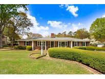 Charming brick home with manicured lawn, trimmed hedges, and classic architectural details under a sunny sky at 806 S Second St, Smithfield, NC 27577