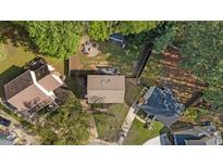 Expansive aerial view of a quaint house with a fire pit in the backyard, surrounded by lush greenery and mature trees at 8333 Bellingham Cir, Raleigh, NC 27615