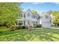 Traditional two-story home featuring black shutters, a well-manicured lawn, and a brick front stairway at 102 Cockleshell Ct, Cary, NC 27513