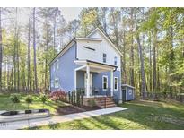 Charming two-story home featuring blue siding, a covered front porch, manicured landscaping and an additional small storage building at 107 Hillcrest Ave # C And D, Carrboro, NC 27510